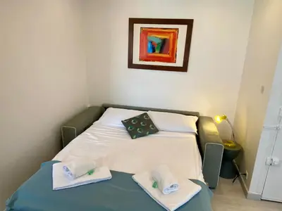 a small room with a bed with towels on it at STUDIO VERT FSHH in Nice