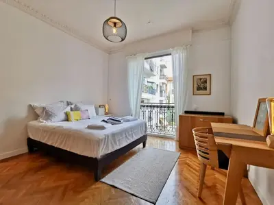a bedroom with a bed and a desk and a window at Appartement Nice Bellecour in Nice