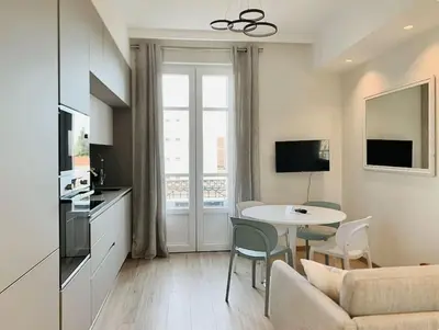a living room with a couch and a table with chairs at Bright, newly renovated apartment in Nice