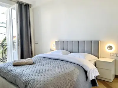 a bedroom with a large bed with a window at Bright, newly renovated apartment in Nice