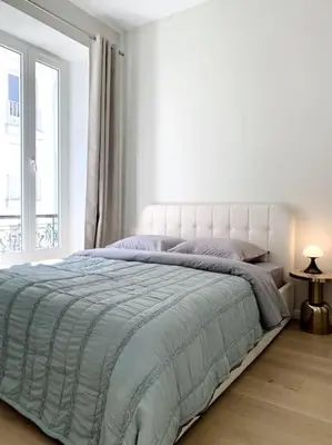 a white bedroom with a bed with a large window at Luxuriously furnished bright newly renovated oasis in Nice