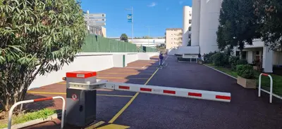 a person walking in a parking lot next to a building at Studio cosy front de mer à 5min de Nice in Saint-Laurent-du-Var