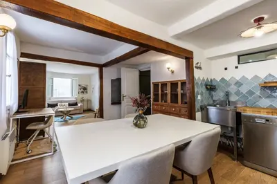 a kitchen and dining room with a white table and chairs at Chic Old Town Apartment in Nice