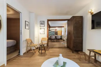 a living room with a table and a bedroom at Chic Old Town Apartment in Nice