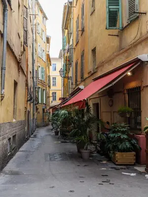 an empty alley with buildings and plants on a street at Chic Old Town Apartment in Nice