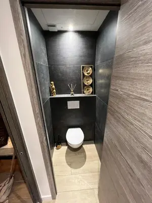 a bathroom with a toilet and a black wall at Port de Nice belle petite pépite in Nice