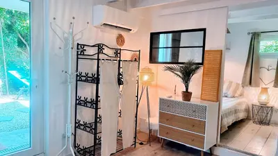 a room with a bedroom with a bed and a mirror at Serenity - Garden Calm & Air Conditioning Downtown in Saint-Laurent-du-Var