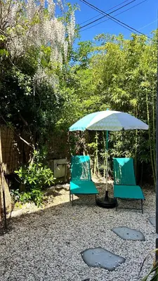 two blue chairs and an umbrella in a yard at Serenity - Garden Calm & Air Conditioning Downtown in Saint-Laurent-du-Var