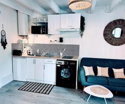 a kitchen with a blue couch and a dishwasher at Serenity - Garden Calm & Air Conditioning Downtown in Saint-Laurent-du-Var