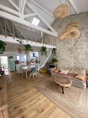 a living room with a couch and a stone wall at Magnifique maison de pecheur face à la mer in Cagnes-sur-Mer
