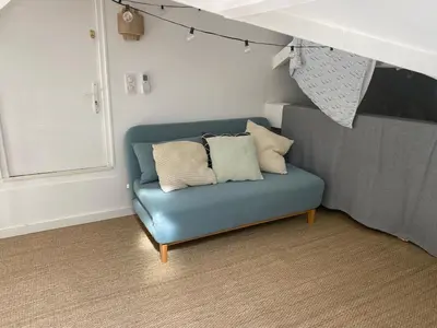 a blue couch with pillows in a living room at Magnifique maison de pecheur face à la mer in Cagnes-sur-Mer
