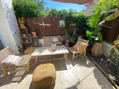 a patio with a table and chairs and a fence at Magnifique maison de pecheur face à la mer in Cagnes-sur-Mer