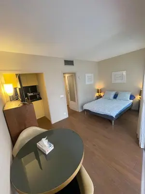 a living room with a bed and a table in a room at Royal lux promenade des anglais in Nice