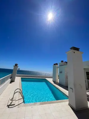 a swimming pool with the ocean in the background at Royal lux promenade des anglais in Nice