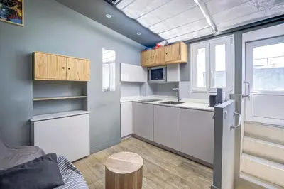 a kitchen with white cabinets and a refrigerator and a window at Maison Bianchi - Jean Médecin in Nice