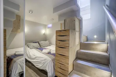 a small bedroom with a bed and a staircase at Maison Bianchi - Jean Médecin in Nice