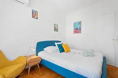 a bedroom with a blue bed and a chair at Terrasse des Oliviers in Nice