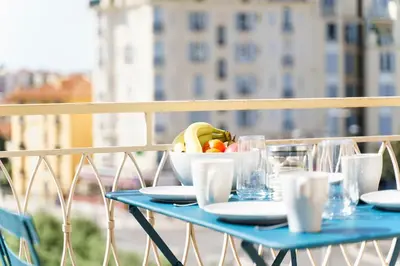 a blue table with a bowl of fruit on a balcony at Terrasse des Oliviers in Nice