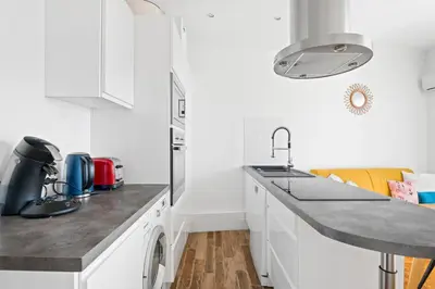 a white kitchen with a counter and a sink at Terrasse des Oliviers in Nice
