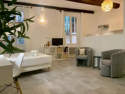 a room with a bed and two chairs and a television at ApartHotel Riviera - Cocon de Gilly - Old Town Promenade des Anglais in Nice