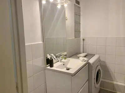 a bathroom with a sink and a washing machine at ApartHotel Riviera - Cocon de Gilly - Old Town Promenade des Anglais in Nice