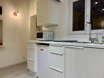 a kitchen with white cabinets and a microwave at ApartHotel Riviera - DUPLEX DE JULES - Large Studio with A C - Old Town Promenade des An in Nice