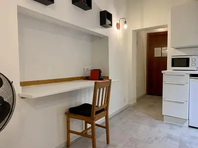 a kitchen with a wooden chair and a microwave at ApartHotel Riviera - DUPLEX DE JULES - Large Studio with A C - Old Town Promenade des An in Nice