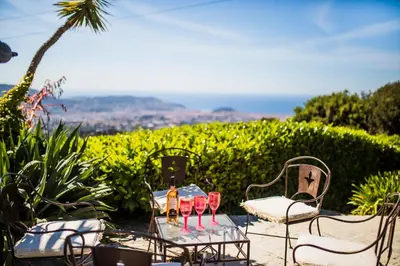 a table with two chairs and wine glasses on it at LOU MAS SOUBRAN VI2083 by RIVIERA HOLIDAY HOMES in Nice