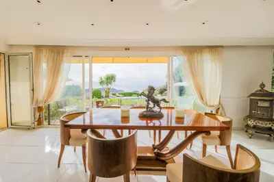 a dining room with a table and chairs and a large window at LOU MAS SOUBRAN VI2083 by RIVIERA HOLIDAY HOMES in Nice