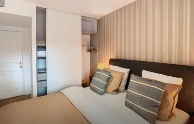 a bedroom with a bed with pillows on it at Appartement Nice Palais de la Méditerranée in Nice