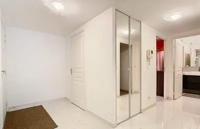 a large white room with a large mirror at Appartement Nice Palais de la Méditerranée in Nice