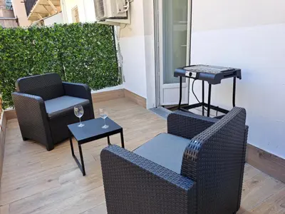a patio with two chairs and a table with glasses at Studio coin nuit terrasse à 5 minutes de la plage N1 in Saint-Laurent-du-Var