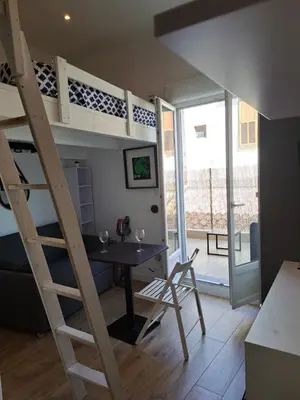 a room with a desk and a loft bed at Studio coin nuit terrasse à 5 minutes de la plage N1 in Saint-Laurent-du-Var