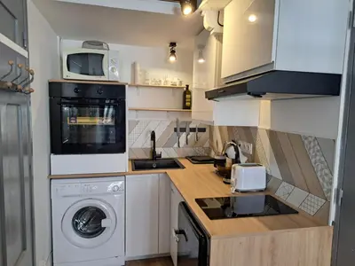a kitchen with a washing machine and a microwave at Studio coin nuit terrasse à 5 minutes de la plage N1 in Saint-Laurent-du-Var