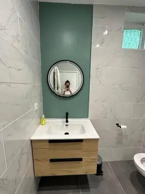 a person taking a picture of a bathroom with a mirror at Cosy Nice appartement in Nice