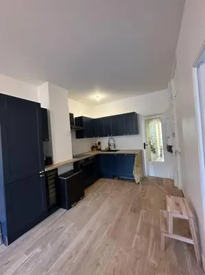 a kitchen with blue cabinets and a wooden floor at Cosy Nice appartement in Nice