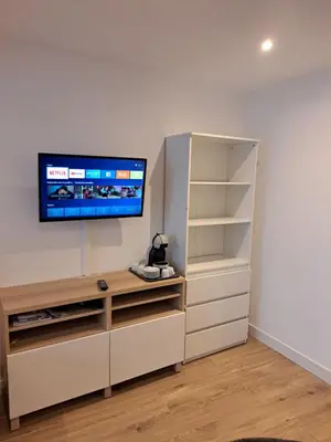 a living room with a tv on a wall at Studio avec Terrasse à 5 minutes de la plage N6 in Saint-Laurent-du-Var