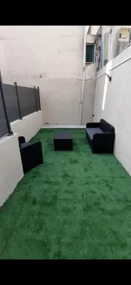 an empty room with chairs and green grass at Studio avec Terrasse à 5 minutes de la plage N6 in Saint-Laurent-du-Var