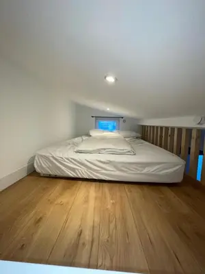 a large bed in a room with a wooden floor at Appartement 3 pièces à 5 minutes de la plage N7 in Saint-Laurent-du-Var