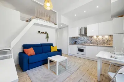 a living room with a blue couch and a table at Nice Renting - GAUTIER - Elegance Height Port & Castle Nice in Nice