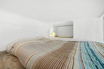 a large bed in a white room with a mirror at Nice Renting - GAUTIER - Elegance Height Port & Castle Nice in Nice
