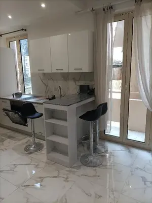 a kitchen with a counter and two stools in a room at Appartement confortable a proximite de la mer. in Nice