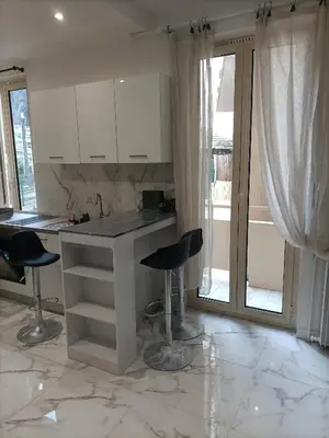 a kitchen with a counter and two bar stools at Appartement confortable a proximite de la mer. in Nice