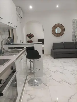 a kitchen with a stool in the middle of a room at Appartement confortable a proximite de la mer. in Nice