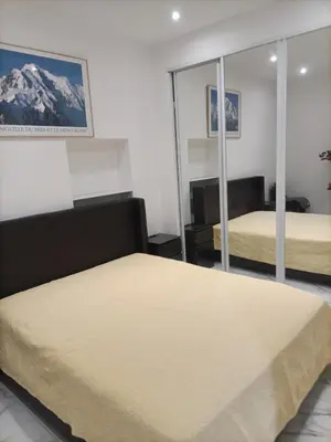 a bedroom with two beds and a mirror at Appartement confortable a proximite de la mer. in Nice