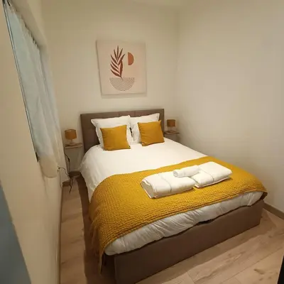 a bedroom with a bed with yellow sheets and yellow pillows at Cocooning Atmosphère old Nice in Nice