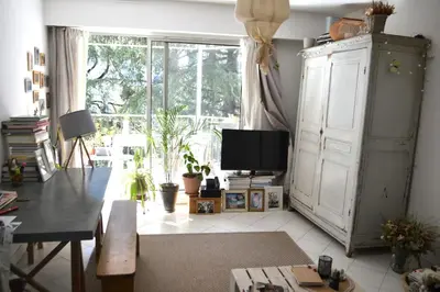 a living room with a tv and a large window at Appartement super clair in Nice