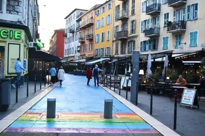 a street with a rainbow painted on the sidewalk at Appartement super clair in Nice