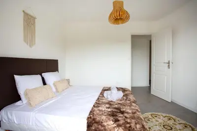 a bedroom with a large white bed with a blanket on it at 4 pièces 8 personnes proche aéroport,tramway in Nice