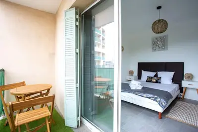 a bedroom with a bed and a table and a glass door at 4 pièces 8 personnes proche aéroport,tramway in Nice